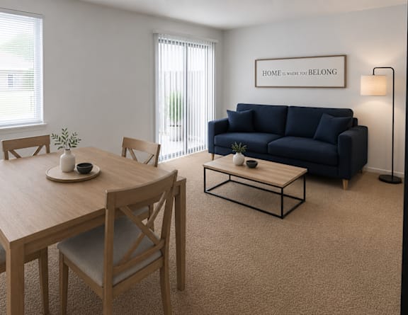 A living room with a wooden table and chairs, a blue couch, and a sign that says "Home is where you belong."