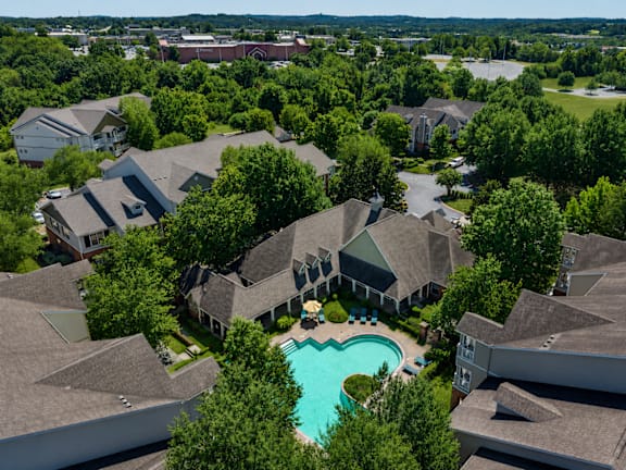 A bird's eye view of a residential area with houses and a swimming pool.