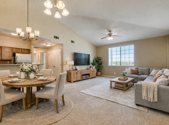 A well-lit living room with a dining table and chairs.