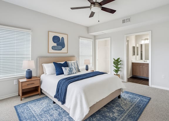 A bedroom with a bed, a ceiling fan, and a rug.