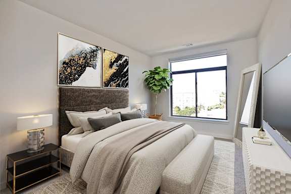 A bedroom with a large bed and a painting on the wall.