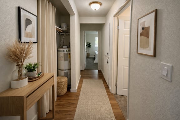 A hallway with a wooden bench and a rug on the floor.
