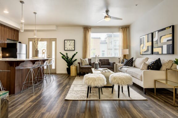 A modern living room with a white couch, a coffee table, and a bar area.