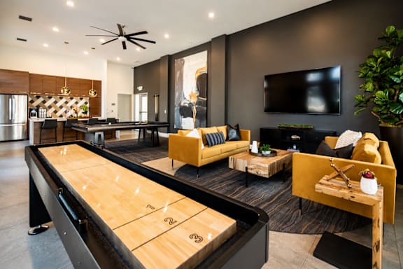A shiny wooden air hockey table is in the middle of a modern living room.