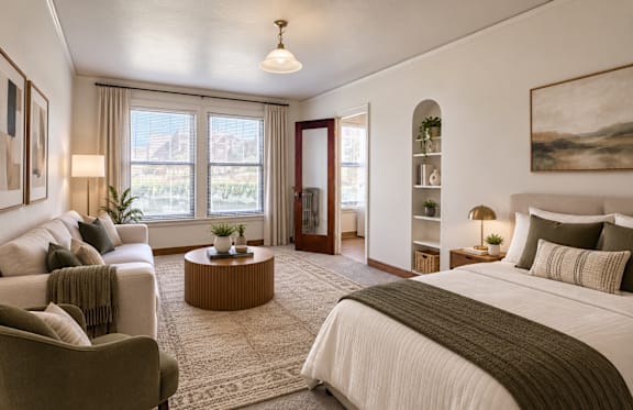 A well-lit bedroom with a large bed and a comfortable chair.