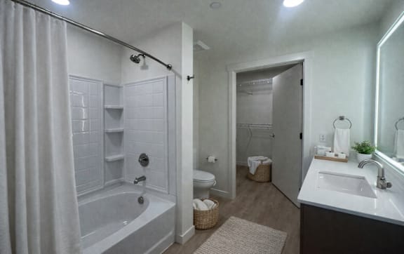 A bathroom with a white tub and sink.