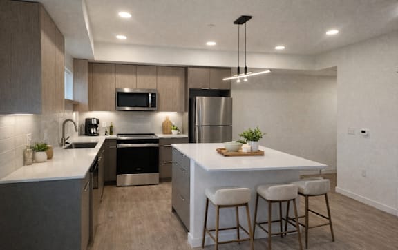 A modern kitchen with a bar area and stools.