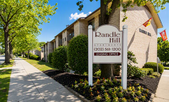 A sign for Randle Hill Apartments stands in front of apartment buildings.
