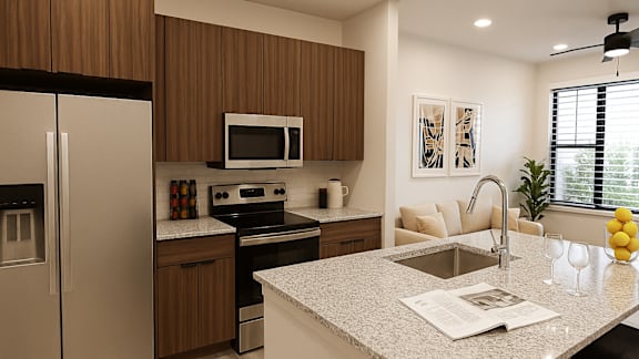 A kitchen with a refrigerator, microwave, oven, and sink.