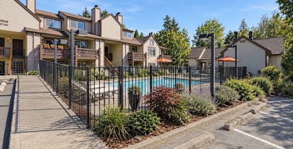 A pool with a hot tub in front of a house.