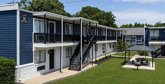 A blue and white building with a black staircase leading to the second floor.