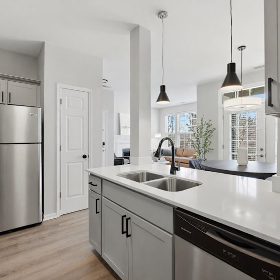 A modern kitchen with dark grey cabinets and a black island.