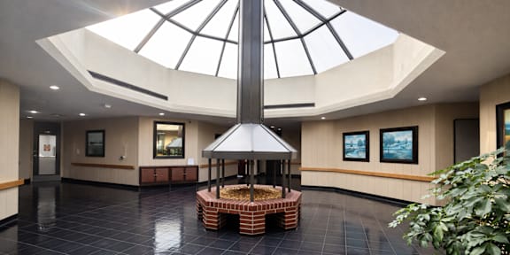A large atrium with a black tiled floor and a glass roof.