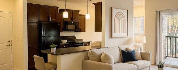 A modern kitchen with dark brown cabinets and a black refrigerator.