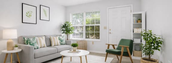 A living room with a grey couch, a green chair, and a white coffee table.