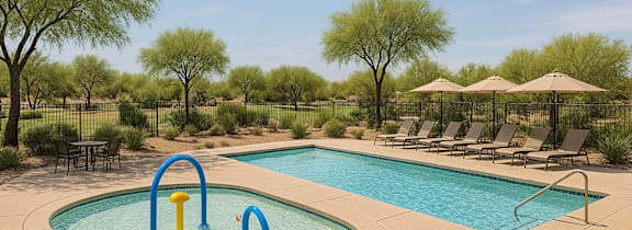A pool with a slide and a pool table.