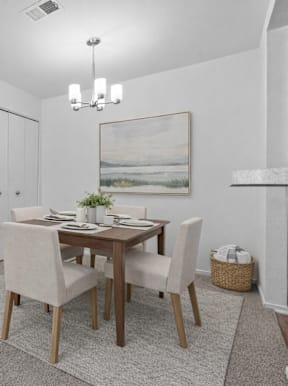 A modern kitchen with a dining table set for two.