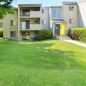A grassy area in front of apartment buildings.