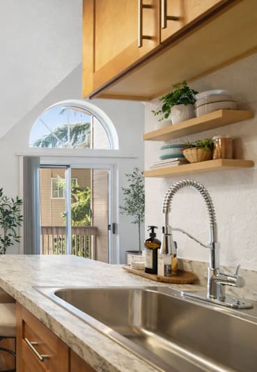 a kitchen with wooden cabinets and a stainless steel refrigerator  at Park 210 Apartment Homes, Edmonds, WA