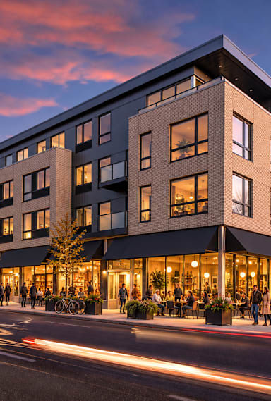 A modern multi-story building with a lit up front at dusk.