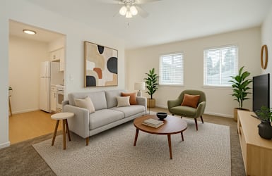 A living room with a grey couch, a green armchair, a coffee table, and a ceiling fan.