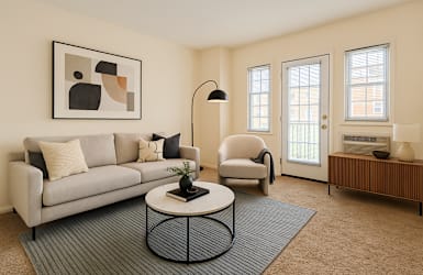 A living room with a grey couch, a black floor lamp, and a framed picture on the wall.