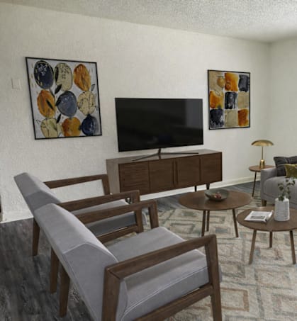 A living room with a grey couch, a wooden coffee table, a TV, and two chairs.