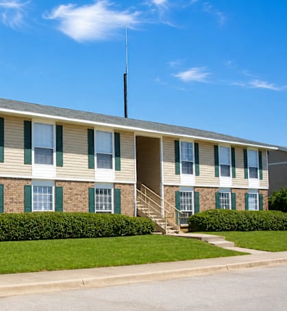 A building with a green lawn in front.