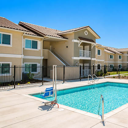 A swimming pool in front of a row of houses.