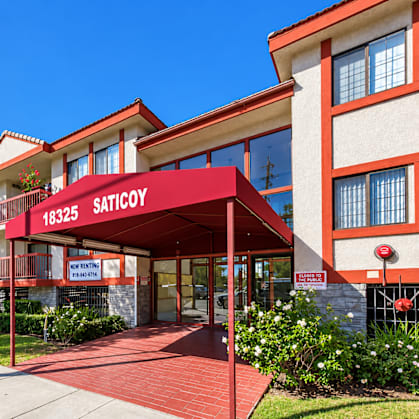A red and white building with the sign "SATICOY" on it.