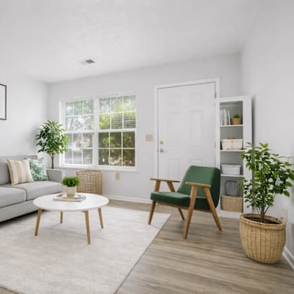A living room with a grey couch, a green chair, and a white coffee table.