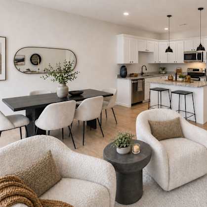 A modern kitchen with white cabinets and a black refrigerator.
