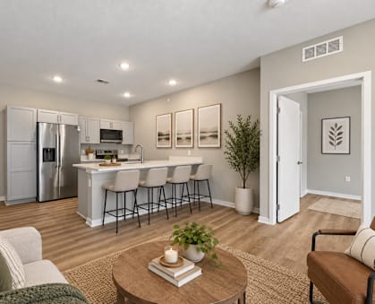 A modern kitchen with a breakfast bar and a living room with a couch.
