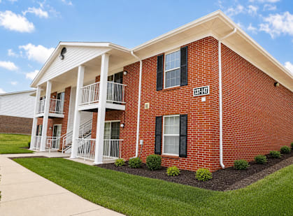 A red brick building with a white porch and a sign that says "1074".