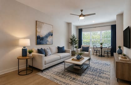 A living room with a white couch, a coffee table, and a painting on the wall.