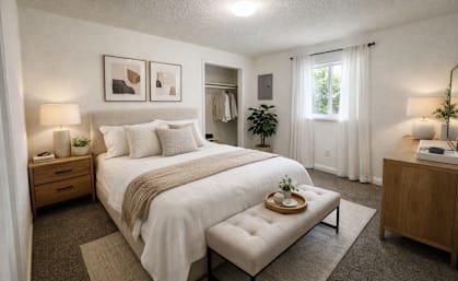 A bedroom with a large bed and a bench in front of it.