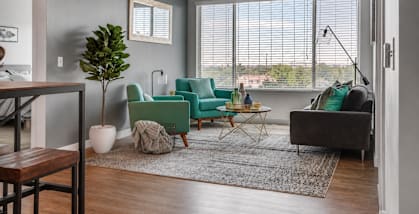 A living room with a green chair and a grey couch.