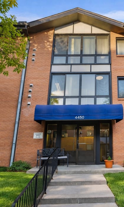 The image shows a brick building with a sign that reads "PARK EMBASSY LEASING OFFICE" and a phone number.