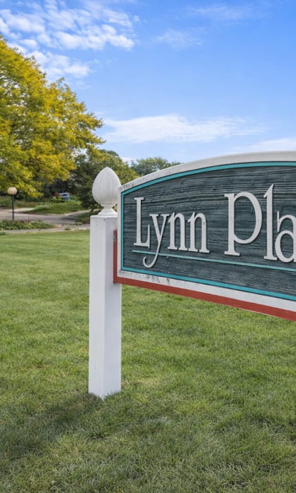 A sign that says Lynn Plaza stands in a grassy area.