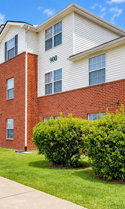 Apartment building with red brick and white siding.