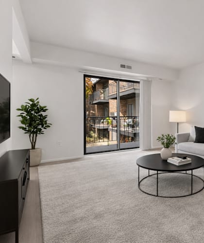 A living room with a grey couch, a coffee table, and a framed picture of a city skyline on the wall.