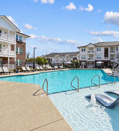 A swimming pool with a slide in front of apartment buildings.