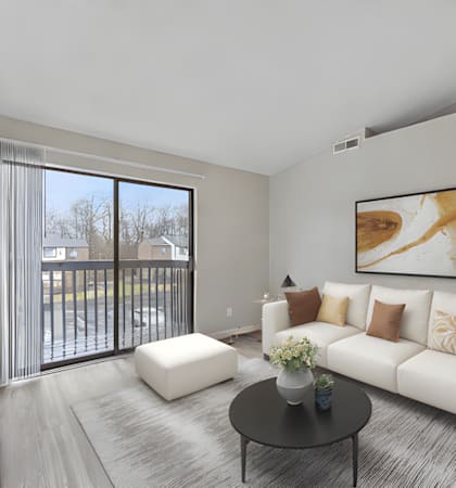 A living room with a white couch and a painting on the wall.