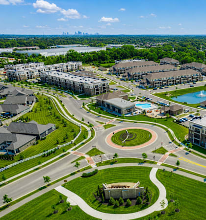 A large, well-maintained residential complex with a swimming pool and a view of a city skyline.