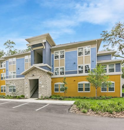 A modern two-story building with a parking lot in front.