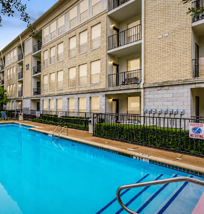 A pool in front of a building with a no swimming sign.
