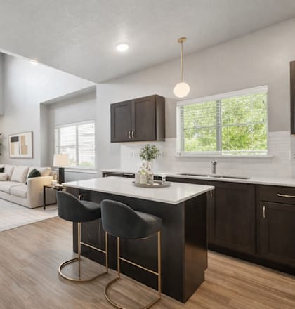 A modern kitchen with a bar stool in front of the island.