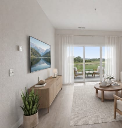 A living room with a large window, a couch, a chair, a table, and a potted plant.