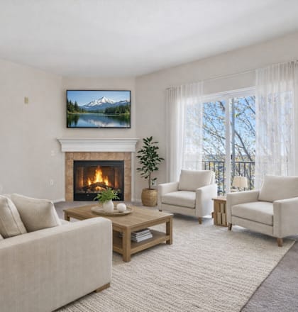 A living room with a fireplace and a painting of a mountain landscape on the wall.