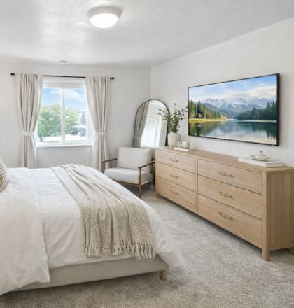 A bedroom with a large bed, a dresser, and a painting on the wall.